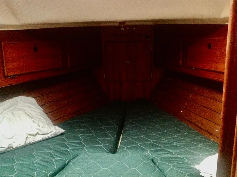 Slide: The Image of Cozy cabin interior of 1983 Whitby 42 Ketch sailboat with wooden finish and green bedding. - 19