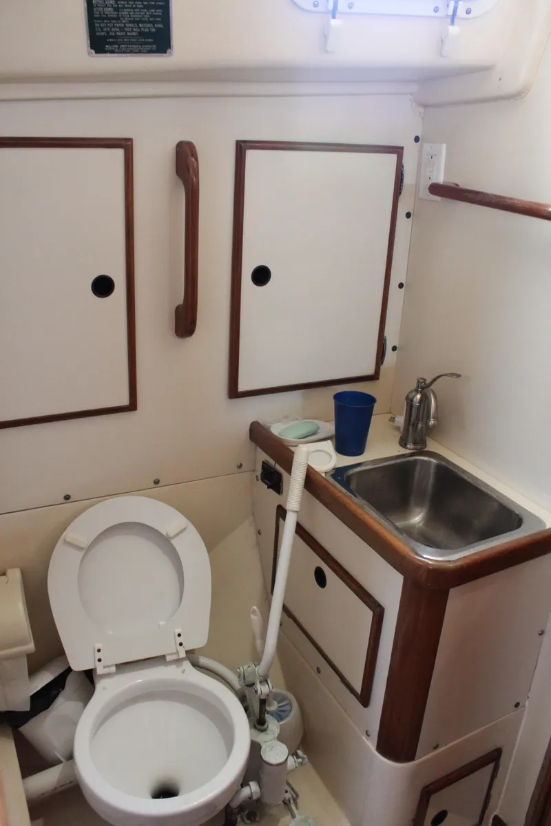 Slide: The Image of 1983 Whitby 42 Ketch bathroom with toilet, sink, and storage cabinets. - 21