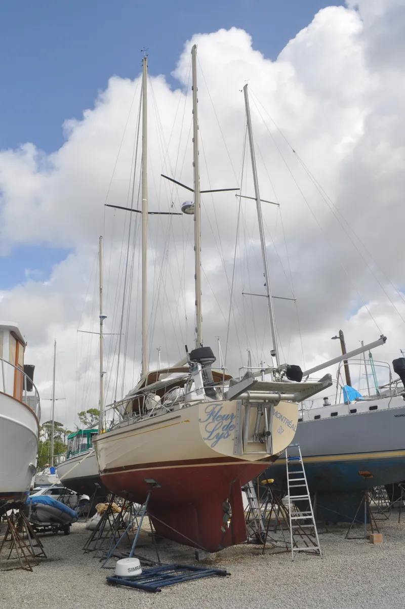 Slide: The Image of 1983 Whitby 42 Ketch sailboat on dry dock under cloudy sky. - 22