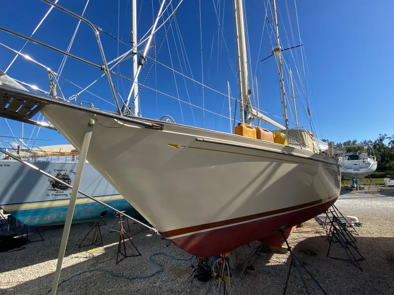 Slide: The Image of 1983 Whitby 42 Ketch sailboat on dry dock under clear blue sky. - 25