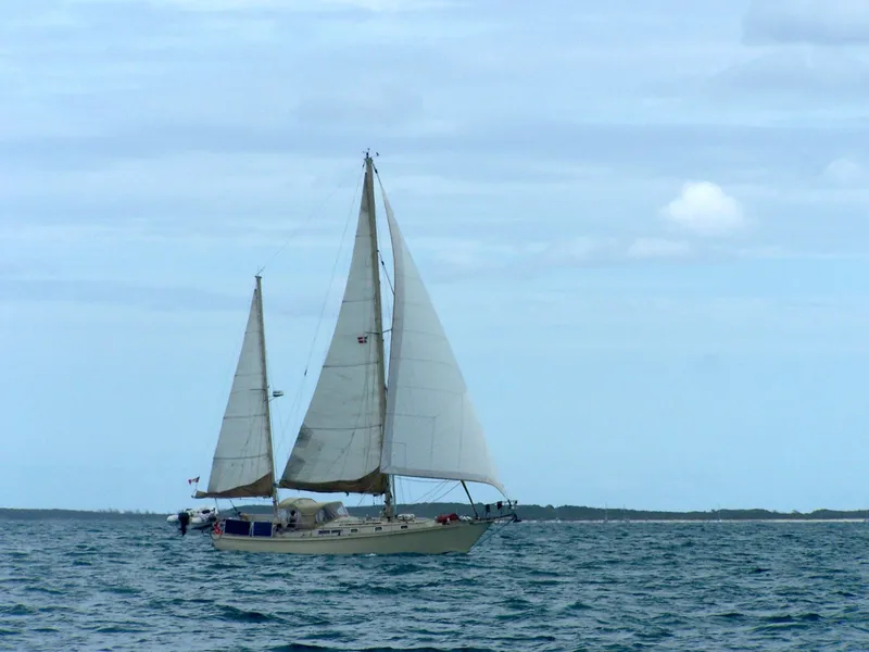 Slide: The Image of 1983 Whitby 42 Ketch sailing on open water under a cloudy sky. - 3