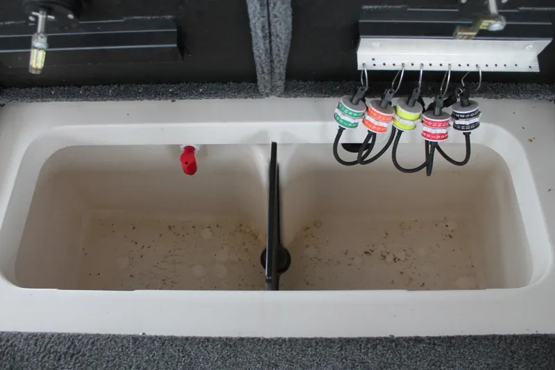 Slide: The Image of 2023 Vexus AVX2080 boat storage compartment with organized fishing line spools. - 11