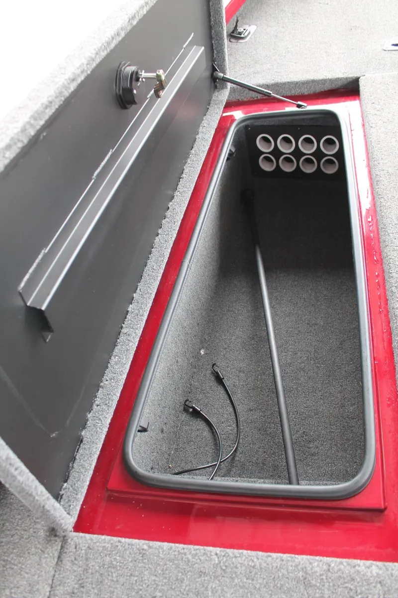 Slide: The Image of 2023 Vexus AVX2080 boat storage compartment with rod holders and carpeted interior. - 8