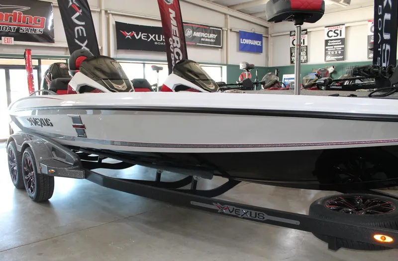 Slide: The Image of 2025 Vexus VXS21 boat on display in showroom with promotional banners. - 10