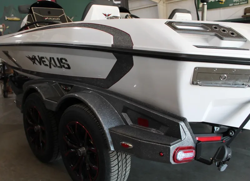 Slide: The Image of 2025 Vexus VXS21 boat, sleek design, dual axle trailer, white and black color scheme. - 24