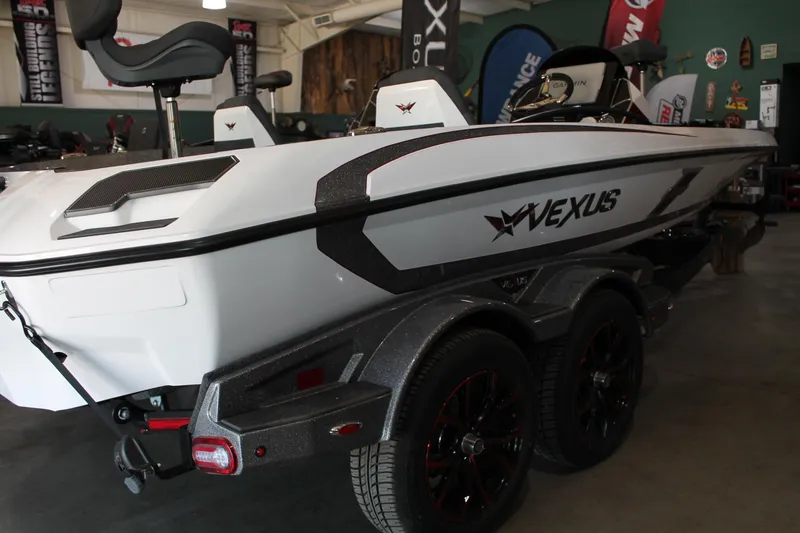 Slide: The Image of 2025 Vexus VXS21 boat in showroom, featuring sleek design and dual-axle trailer. - 8