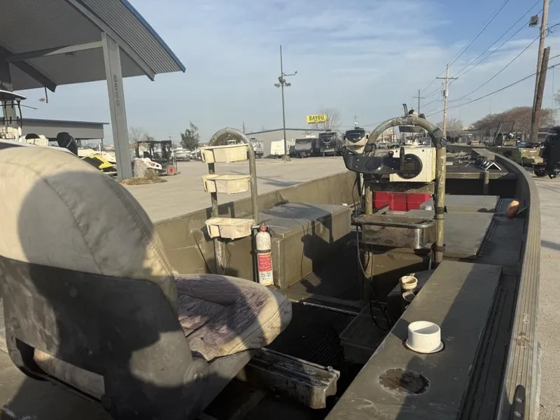 Slide: The Image of 2003 Gator Trax 20' boat interior with seats and steering console, parked outdoors. - 2