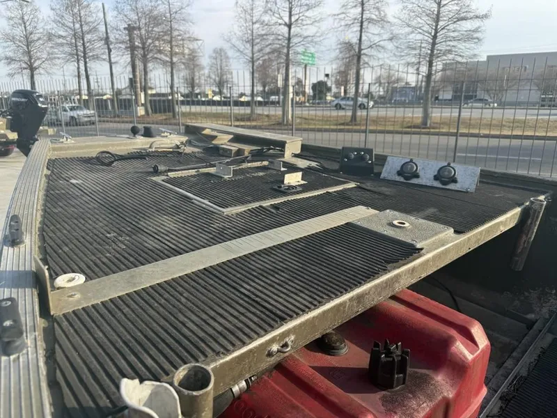 Slide: The Image of 2003 Gator Trax 20' boat deck with equipment, parked near a fence and trees. - 9