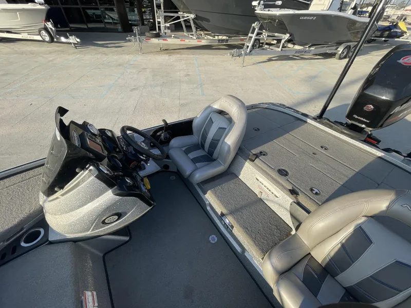 Slide: The Image of 2017 Nitro Z19 boat interior with steering console and seating, parked at a marina. - 5