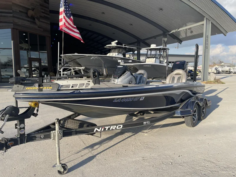 Slide: The Image of 2017 Nitro Z19 boat on trailer, parked outside dealership with American flag. - 8