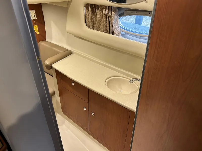 Slide: The Image of 2003 Chaparral 330 Signature Cruiser bathroom with sink and wooden cabinetry. - 17