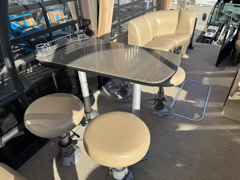 Slide: The Image of 2019 Godfrey Premium 235SD Sundeck interior with beige seating and sleek table design. - 10