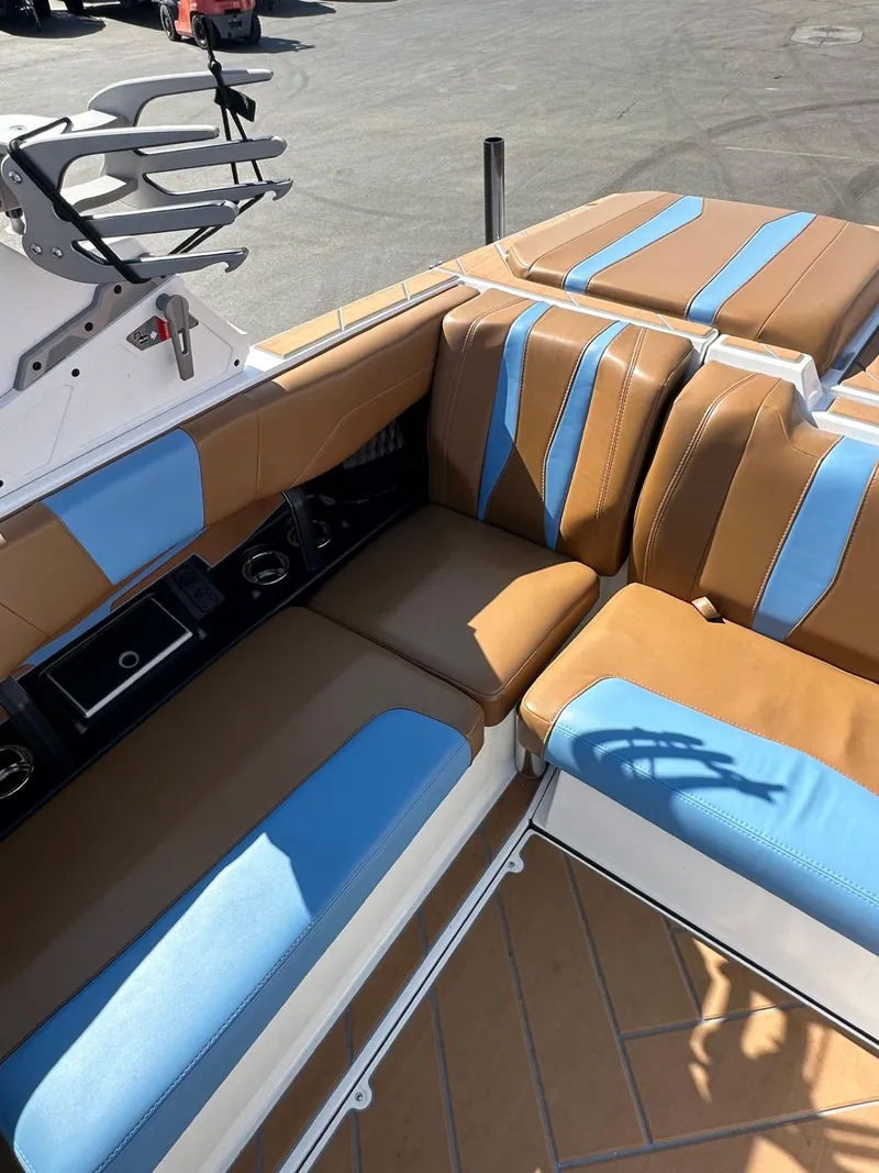 Slide: The Image of 2024 Malibu 22 LSV boat interior with tan and blue seating, showcasing luxury design. - 12