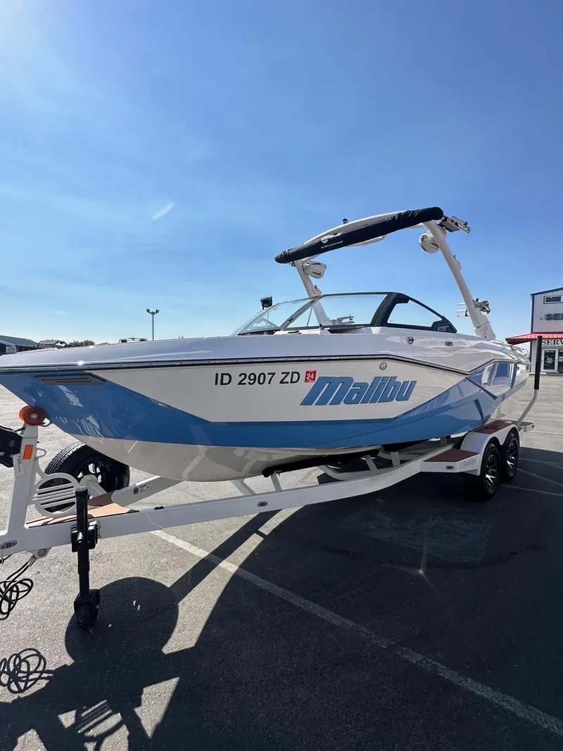 Slide: The Image of 2024 Malibu 22 LSV boat on trailer under clear blue sky. - 5