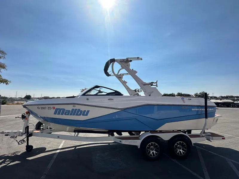 Slide: The Image of 2024 Malibu 22 LSV boat on trailer under clear blue sky. - 6