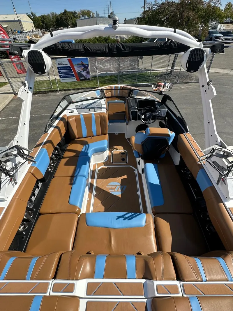 Slide: The Image of 2024 Malibu 22 LSV boat interior with brown and blue seating, modern design. - 9