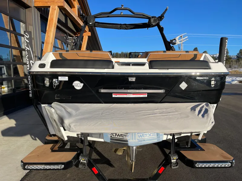 Slide: The Image of 2024 Malibu 22 LSV boat, black and white, parked outdoors on a sunny day. - 4