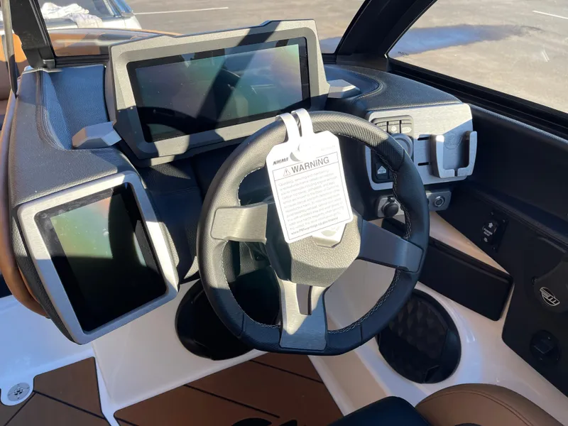 Slide: The Image of 2024 Malibu 22 LSV boat dashboard with modern steering and digital displays. - 6