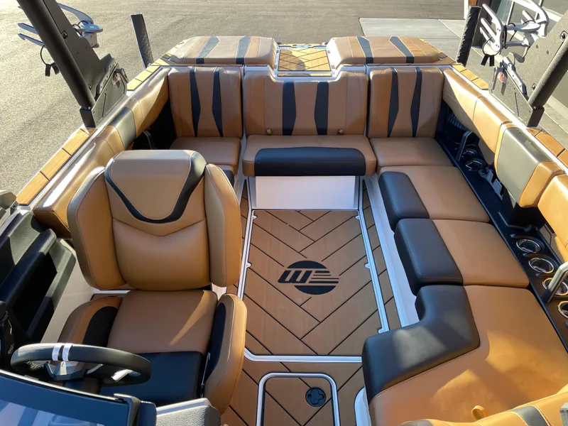 Slide: The Image of 2024 Malibu 22 LSV boat interior with tan and black seating, stylish design. - 8