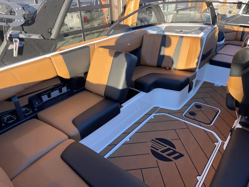 Slide: The Image of 2024 Malibu 22 LSV boat interior with tan and black seating, modern design. - 9