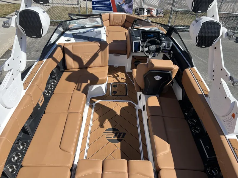 Slide: The Image of 2024 Malibu 23 LSV boat interior with tan seating and modern dashboard. - 12