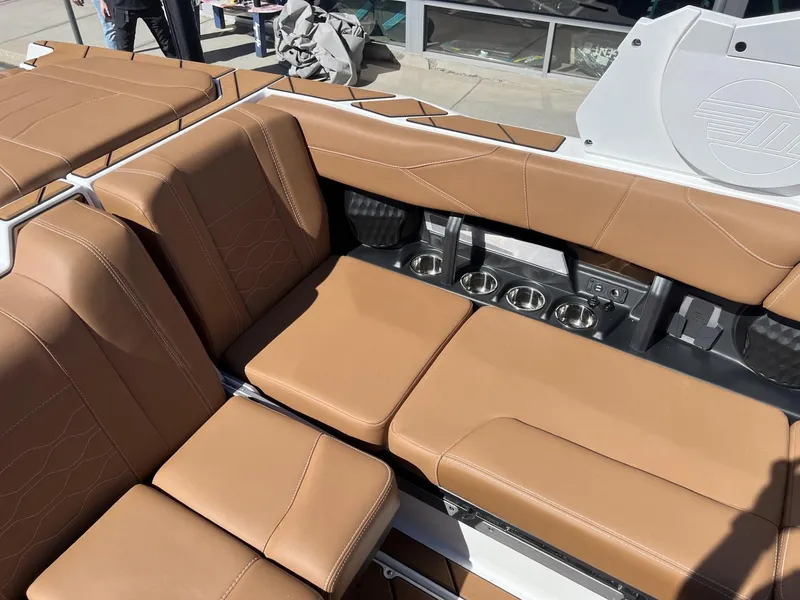 Slide: The Image of 2024 Malibu 23 LSV boat interior with tan leather seats and cup holders. - 13