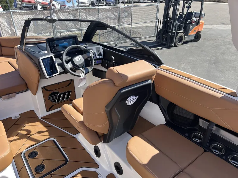Slide: The Image of 2024 Malibu 23 LSV boat interior with tan seating and modern dashboard. - 15