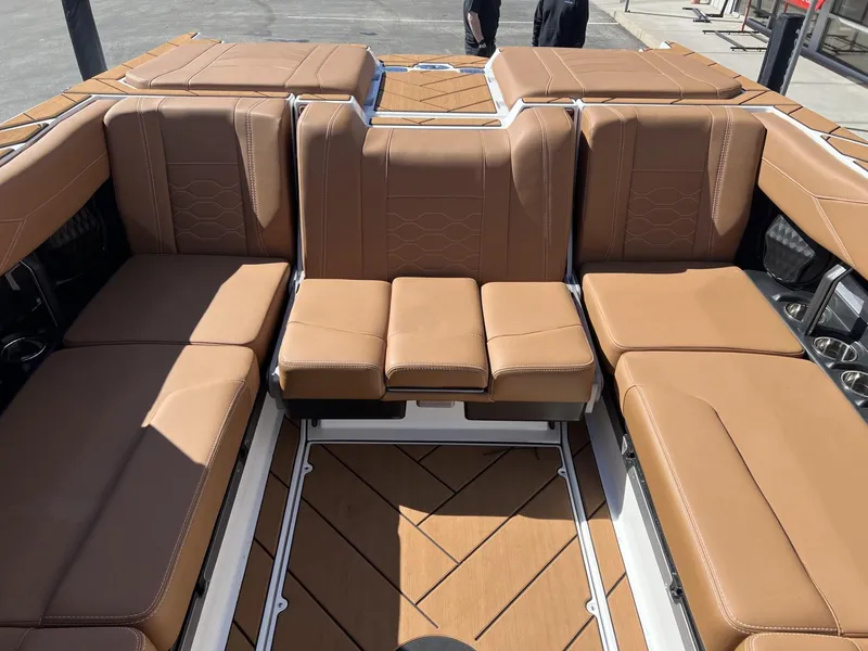 Slide: The Image of 2024 Malibu 23 LSV boat interior with tan leather seating and wood flooring. - 16