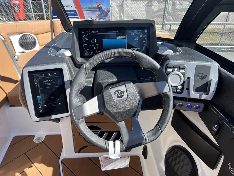 Slide: The Image of 2024 Malibu 23 LSV boat dashboard with steering wheel and digital displays. - 17