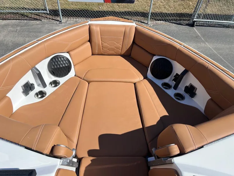 Slide: The Image of 2024 Malibu 23 LSV boat interior with tan leather seating and cup holders. - 18
