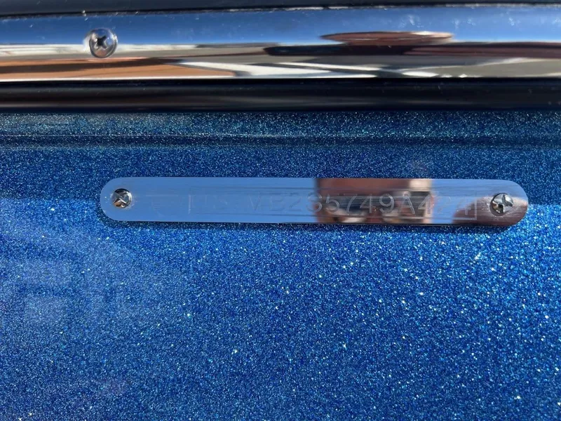 Slide: The Image of 2024 Malibu 23 LSV boat with metallic blue finish and identification plate. - 22