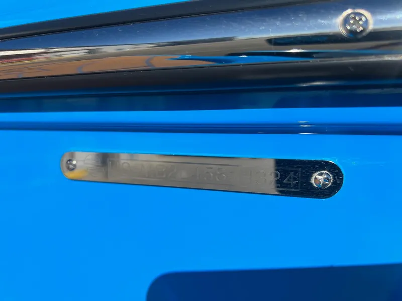 Slide: The Image of Close-up of a 2024 Malibu 24 MXZ boat identification plate on a blue surface. - 22