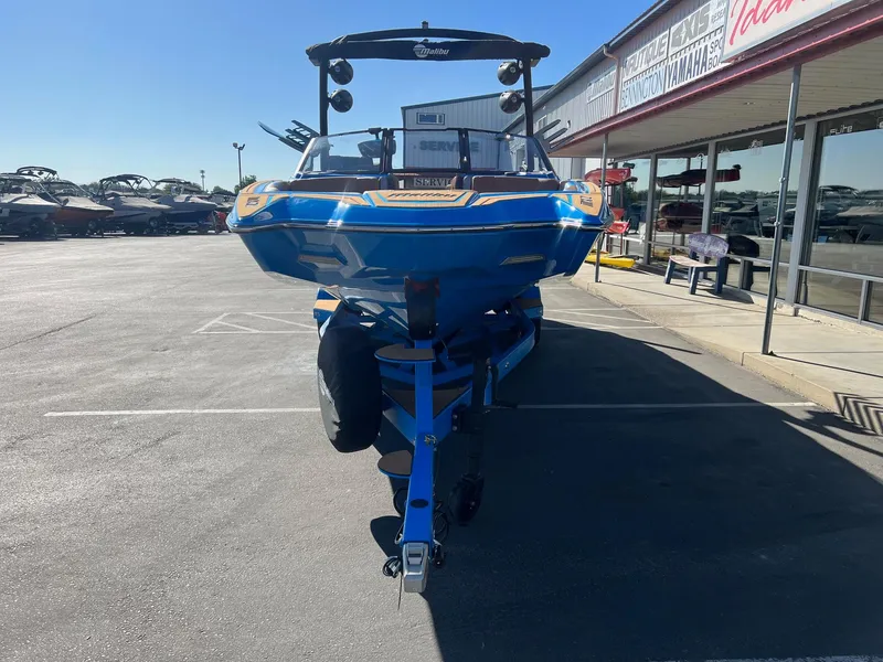 Slide: The Image of 2024 Malibu 24 MXZ boat in a dealership parking lot, front view. - 4