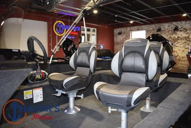 Slide: The Image of 2025 Lund 1650 Rebel XL SS boat interior with two gray seats in showroom. - 10