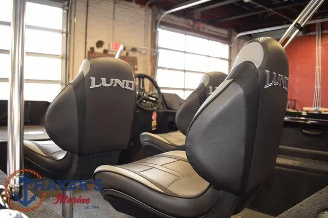 Slide: The Image of 2025 Lund 1650 Rebel XL SS boat interior with branded seats in a showroom. - 12