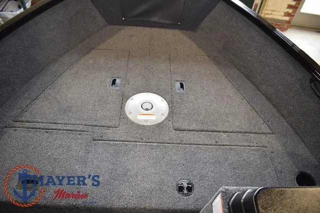 Slide: The Image of 2025 Lund 1650 Rebel XL SS boat interior with carpeted deck and storage compartments. - 13