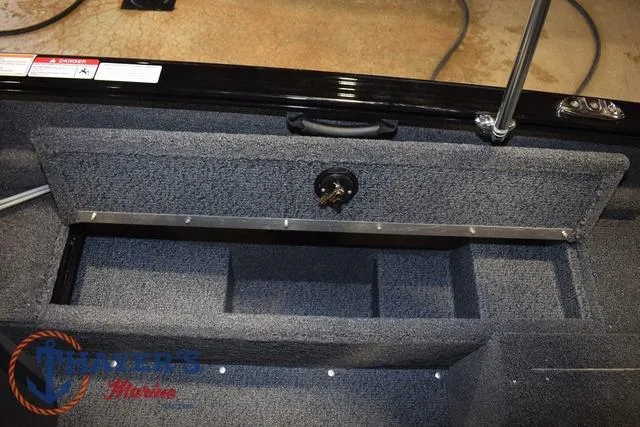 Slide: The Image of 2025 Lund 1650 Rebel XL SS boat interior storage compartment with carpeted finish. - 17