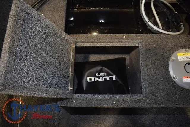 Slide: The Image of 2025 Lund 1650 Rebel XL SS boat storage compartment with logo and wiring visible. - 18