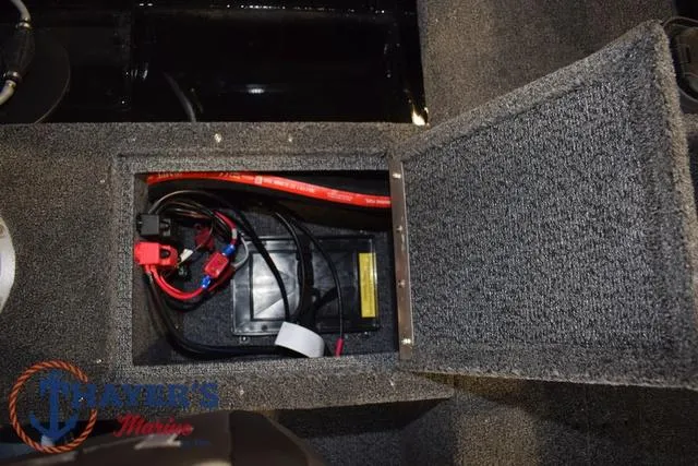Slide: The Image of 2025 Lund 1650 Rebel XL SS boat battery compartment with wiring and carpeted interior. - 19