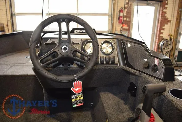 Slide: The Image of 2025 Lund 1650 Rebel XL SS boat interior with steering wheel and dashboard controls. - 21