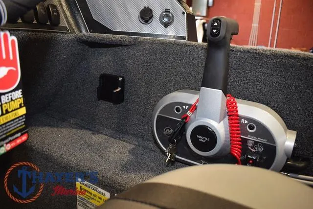 Slide: The Image of Interior of 2025 Lund 1650 Rebel XL SS boat showing throttle control and safety features. - 23