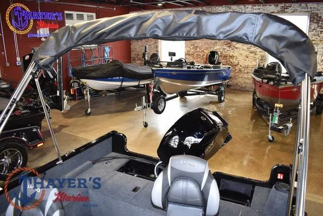 Slide: The Image of 2025 Lund 1650 Rebel XL SS boat displayed in showroom with other boats. - 25
