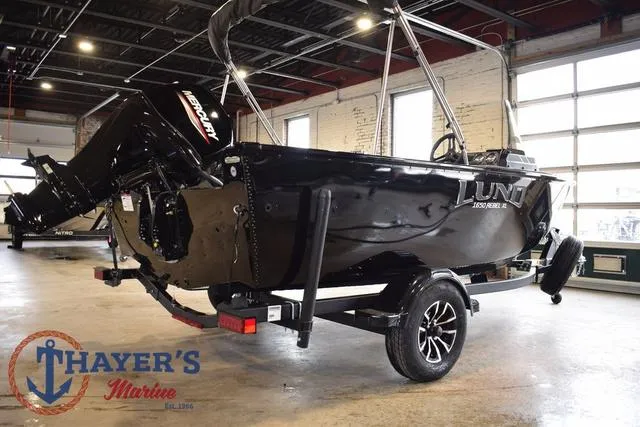 Slide: The Image of 2025 Lund 1650 Rebel XL SS boat in showroom, black exterior, on trailer. - 3