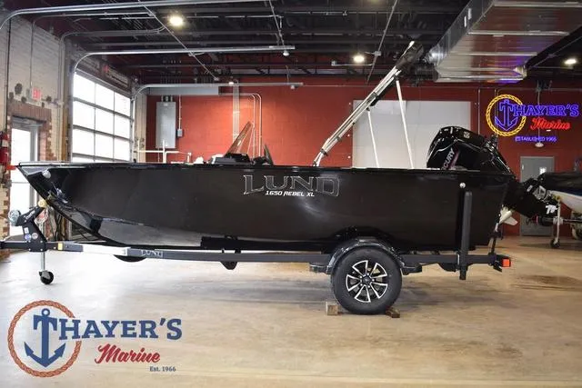 Slide: The Image of 2025 Lund 1650 Rebel XL SS boat displayed at Thayer's Marine showroom. - 6