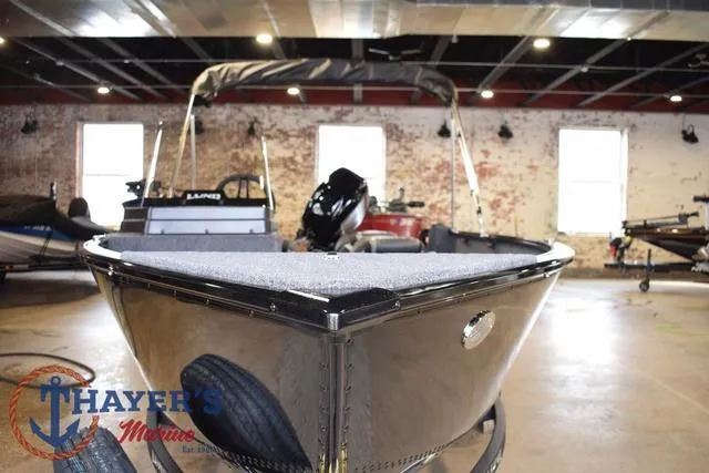 Slide: The Image of 2025 Lund 1650 Rebel XL SS boat displayed indoors at Thayer's Marine showroom. - 8