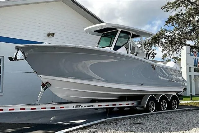 Slide: The Image of 2025 Blackfin 272CC boat cruising on open water, featuring fishing rods and dual engines. - 1