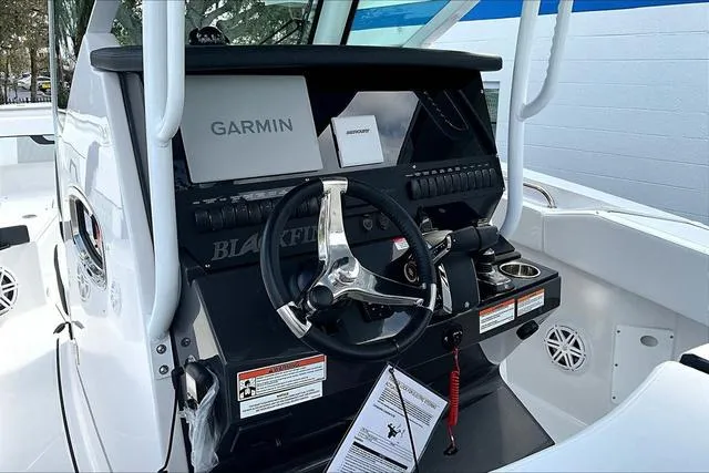 Slide: The Image of 2025 Blackfin 272CC boat dashboard with Garmin navigation system and steering wheel. - 10