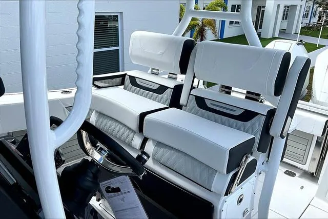 Slide: The Image of 2025 Blackfin 272CC boat interior with luxurious white seating and modern steering console. - 16