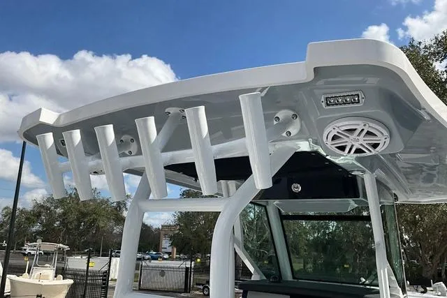 Slide: The Image of 2025 Blackfin 272CC boat with rod holders and speaker, under a clear blue sky. - 31