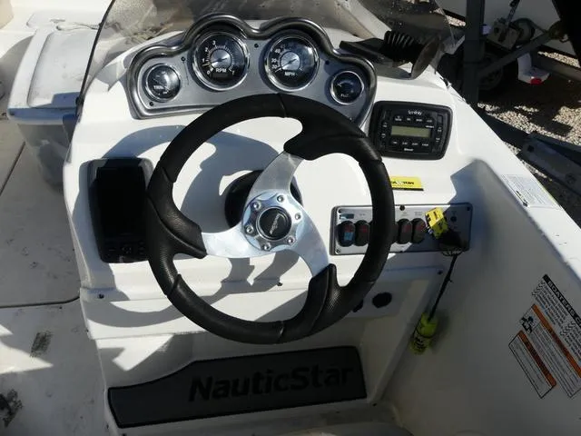 Slide: The Image of 2016 NauticStar 203 DC boat dashboard with steering wheel and gauges. - 10